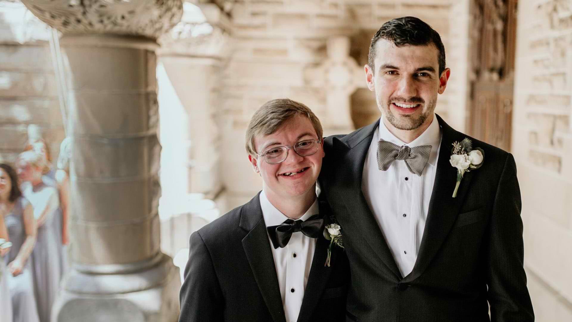Two brothers wearing tuxedos.